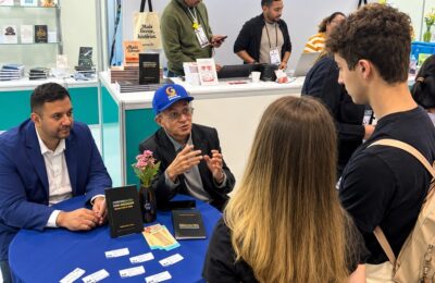 Professor Bibiano Costa de boné azul durante autógrafos na Bienal.
